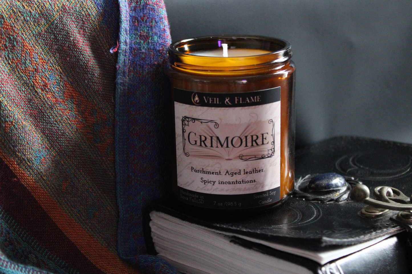 Grimoire candle in a 7 oz glass vessel, handmade in Sioux Falls, SD with parchment, leather, and spicy resin scent notes.