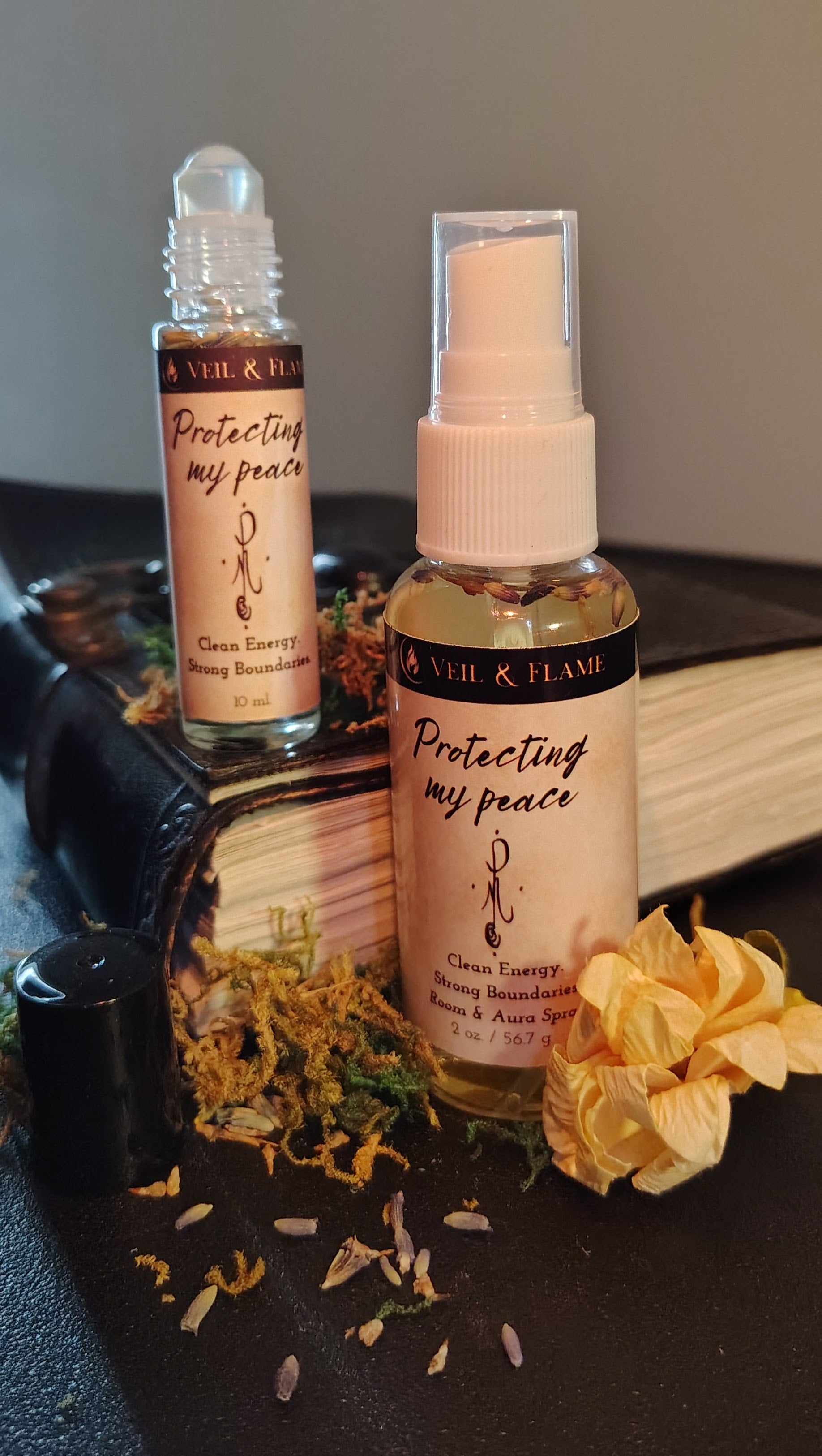 Ritual protection Spray bottle and small protection oil bottle pictured next to a book. 