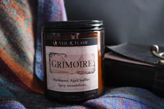 Grimoire candle in a 7 oz glass vessel, handmade in Sioux Falls, SD with parchment, leather, and spicy resin scent notes.