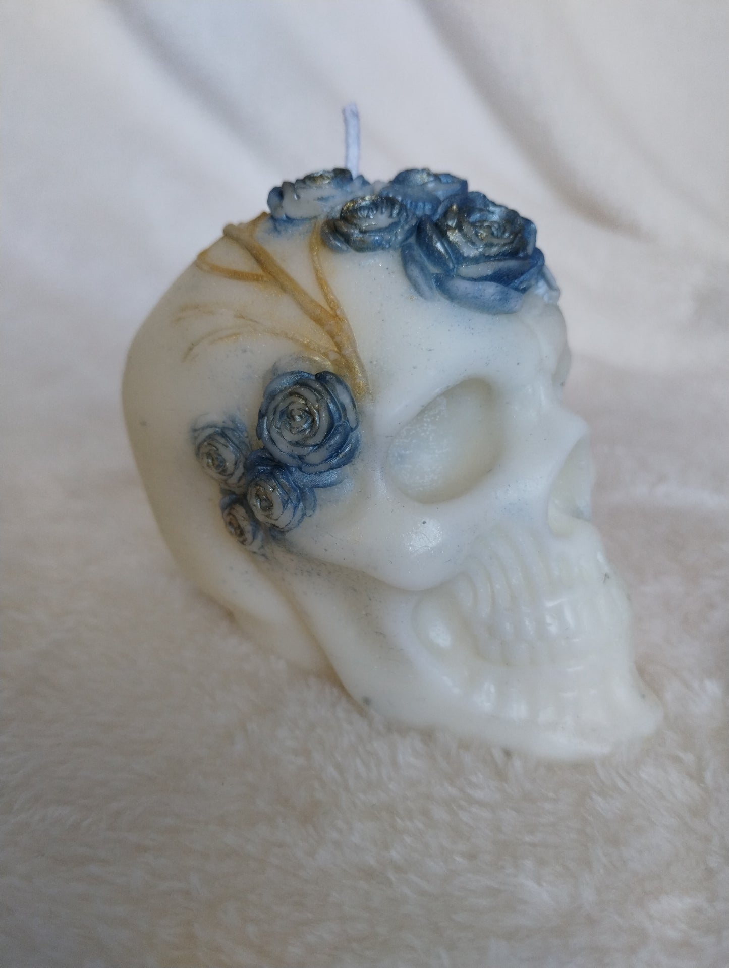 Decorative skull with blue flowers on a textured surface