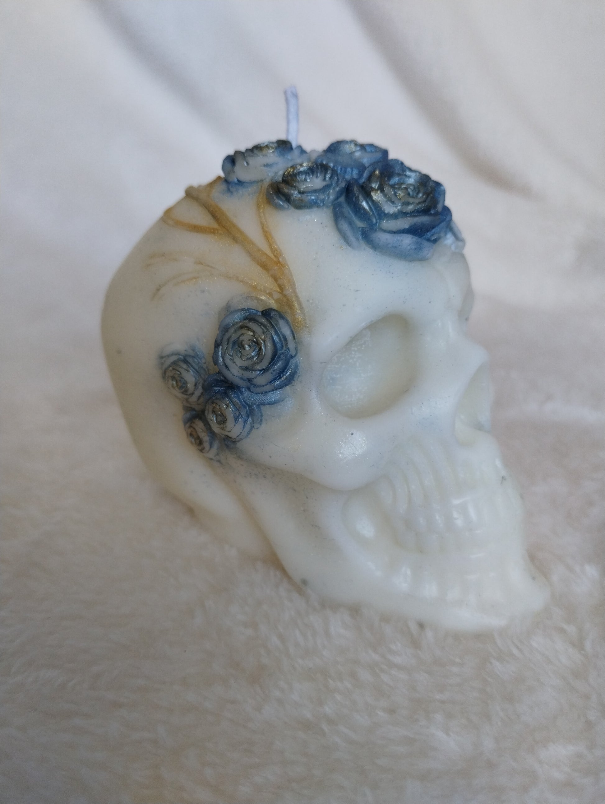 Decorative skull with blue flowers on a textured surface