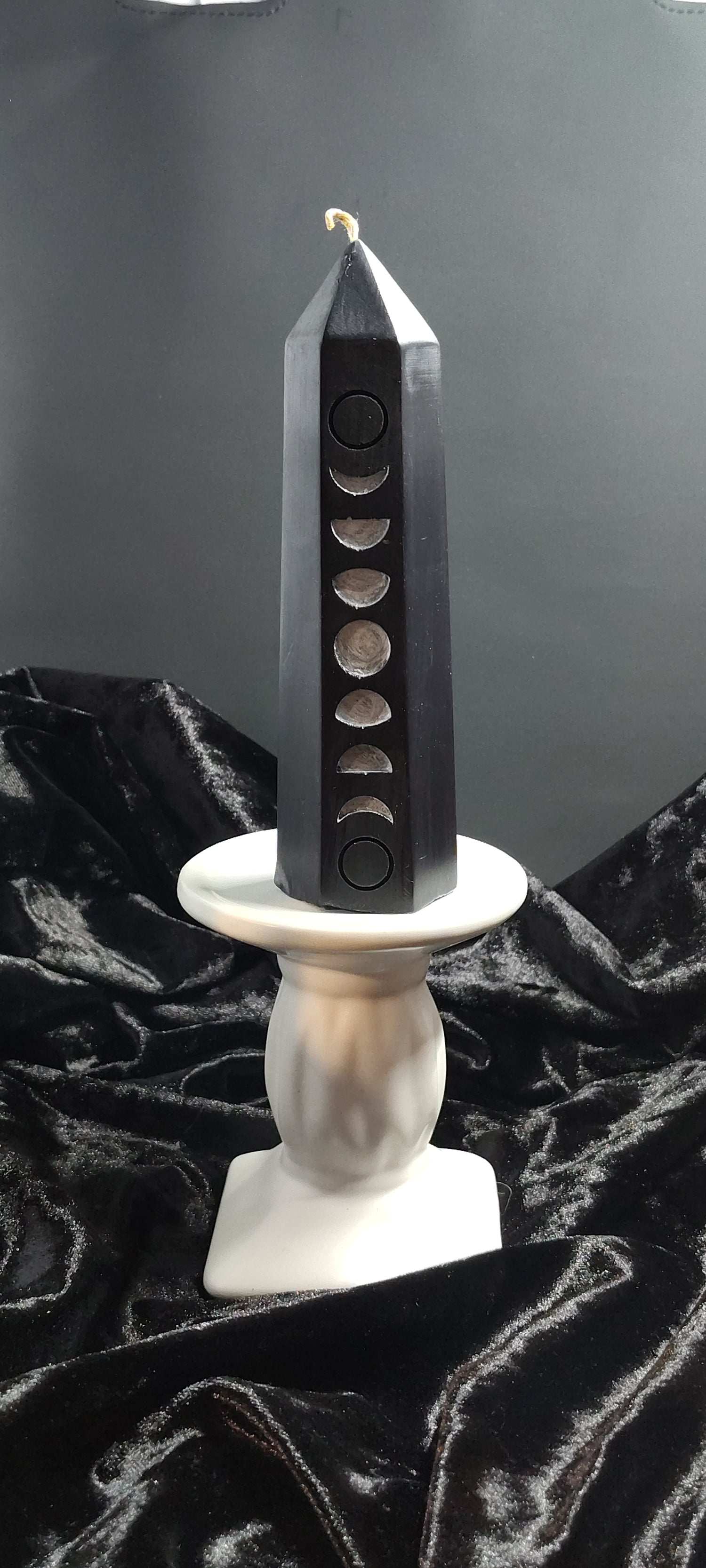 Sword with a black blade and white handle on a dark background