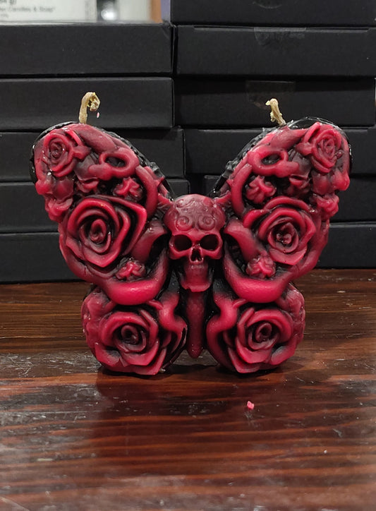 Skull butterfly candle with dual wicks and carved rose‑wing details, handmade in Sioux Falls, SD.