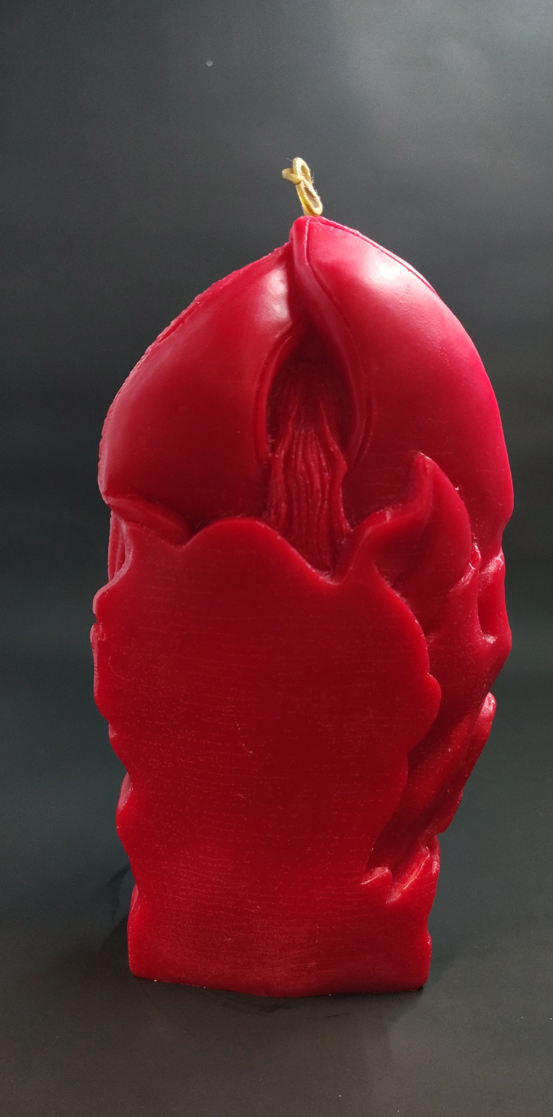 Red lilith candle back side on a black background