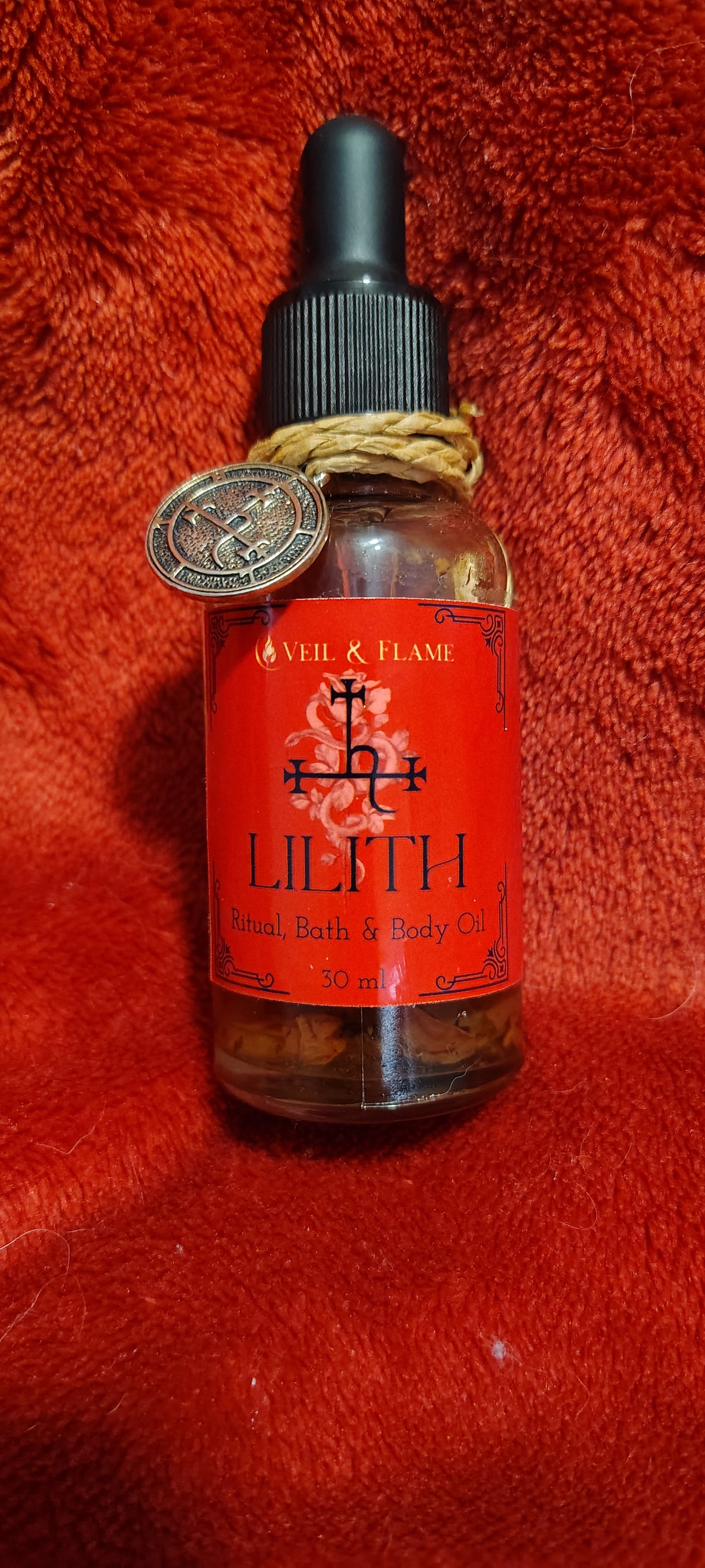 Lilith ritual oil with dragon’s blood, rose petals, and herbs in a 1 oz dropper bottle.
