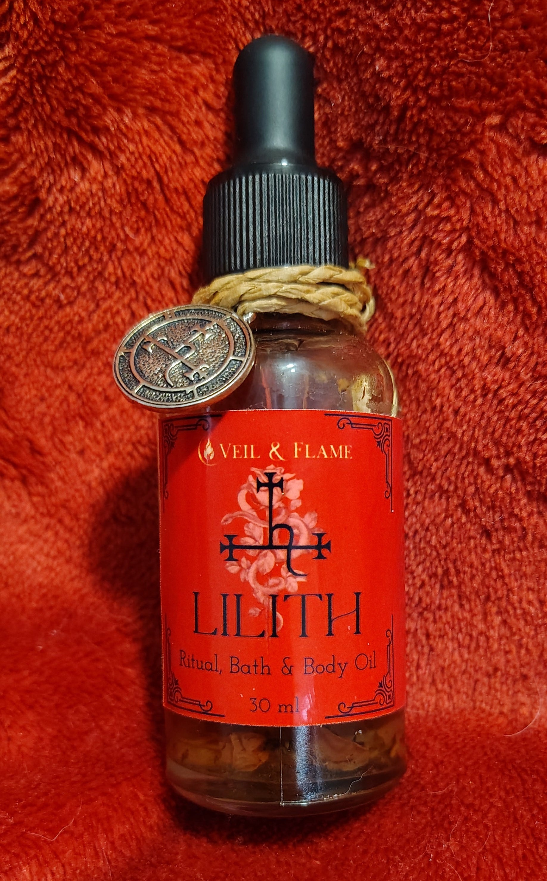 Lilith ritual oil with dragon’s blood, rose petals, and herbs in a 1 oz dropper bottle.