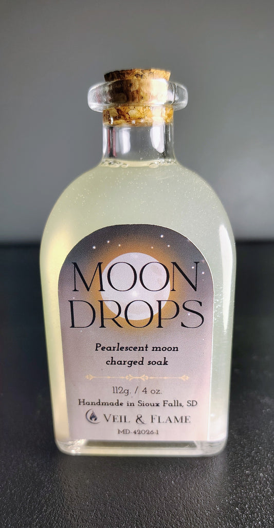Moon Drops bath oil in a glass bottle, creating a milky, moisturizing bath ritual, handmade in Sioux Falls, SD.