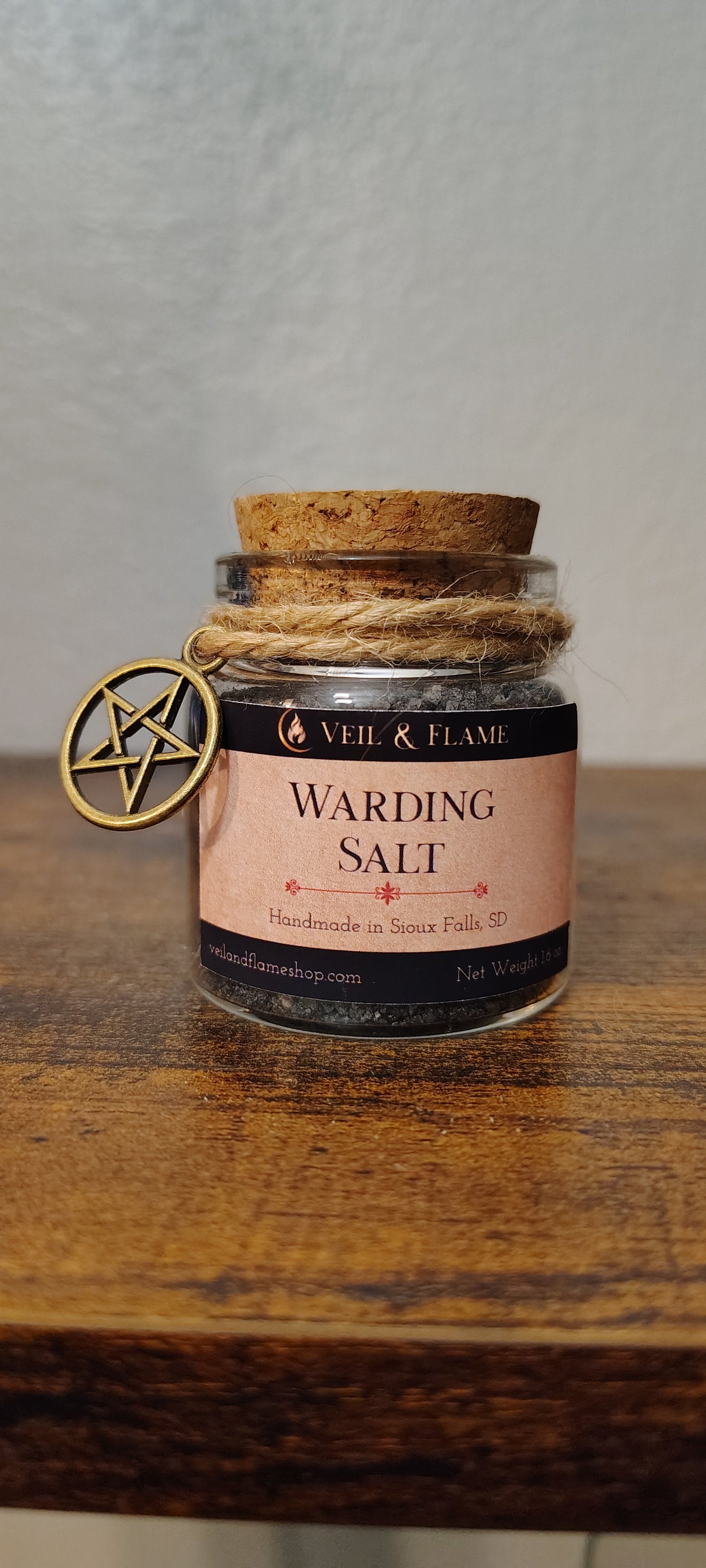 Warding salt in a glass jar with charcoal and herbs, handmade in Sioux Falls, SD.