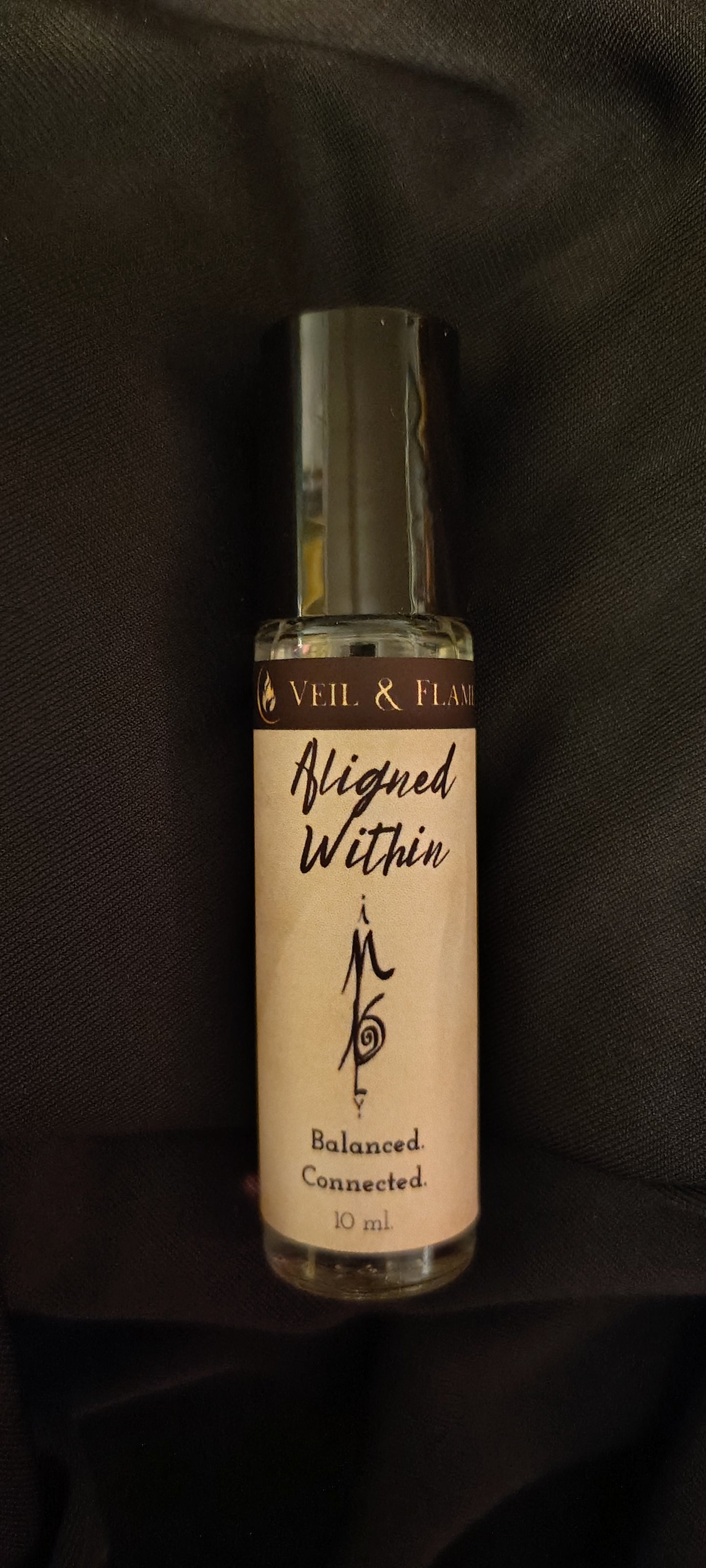 Aligned Within ritual oil with amethyst chips and jasmine buds in a 10 ml roller bottle, handmade in Sioux Falls, SD.