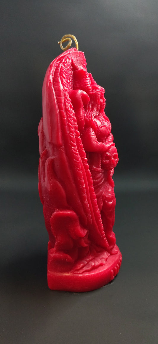 Red candle with intricate design on a black background