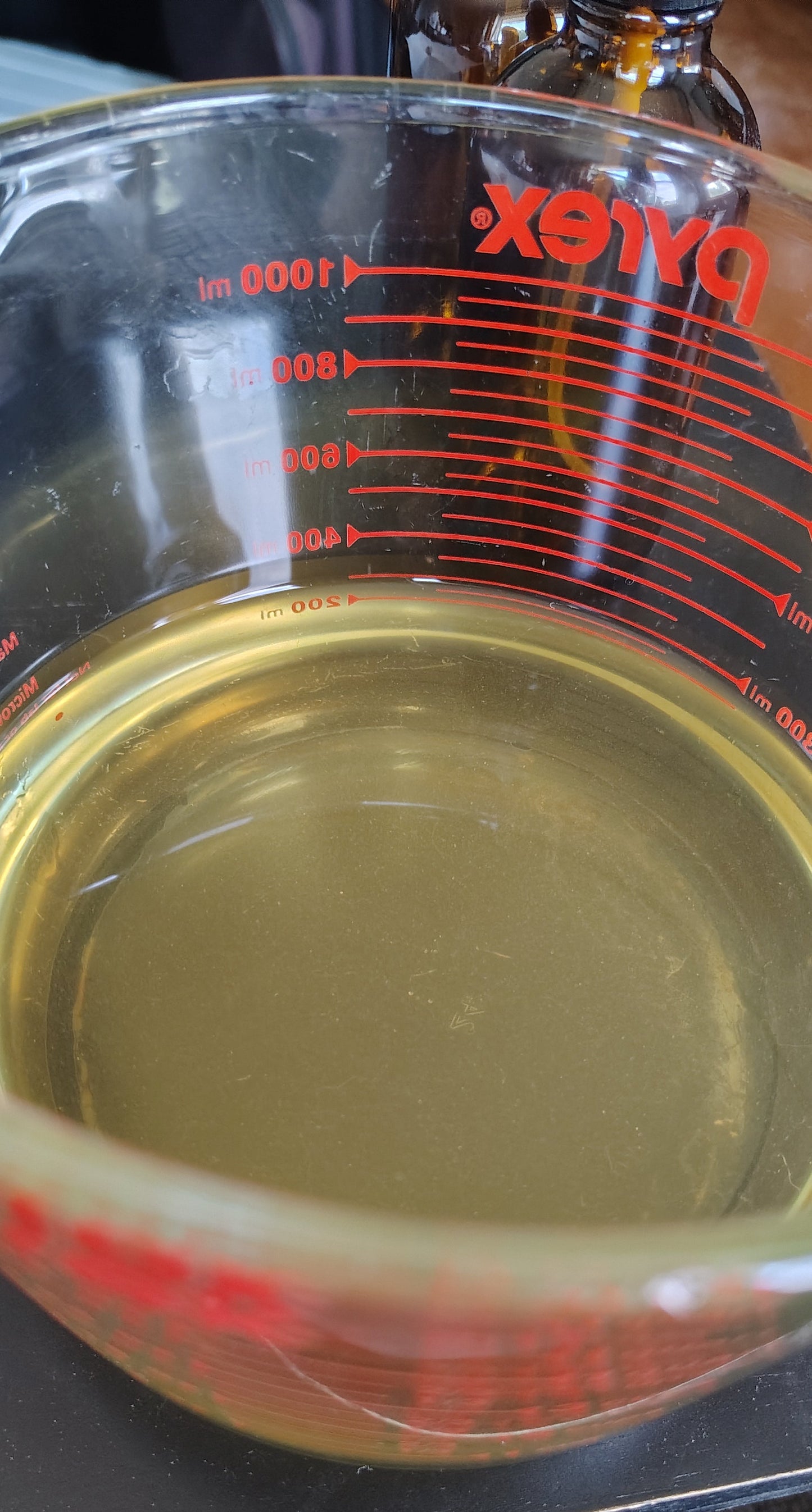 Close-up of a Pyrex measuring cup with botanical water inside to show clarity of the formula. 
