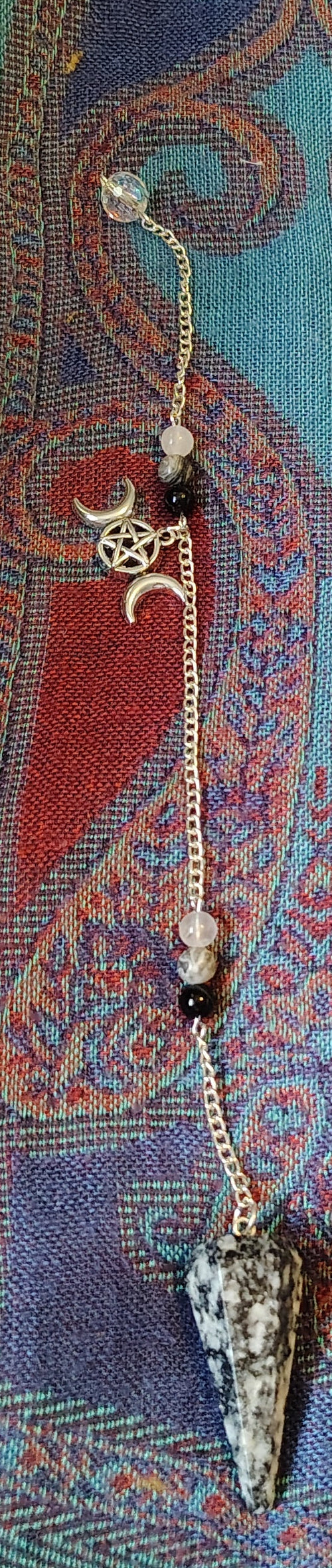 Decorative pendulum on a colorful fabric background