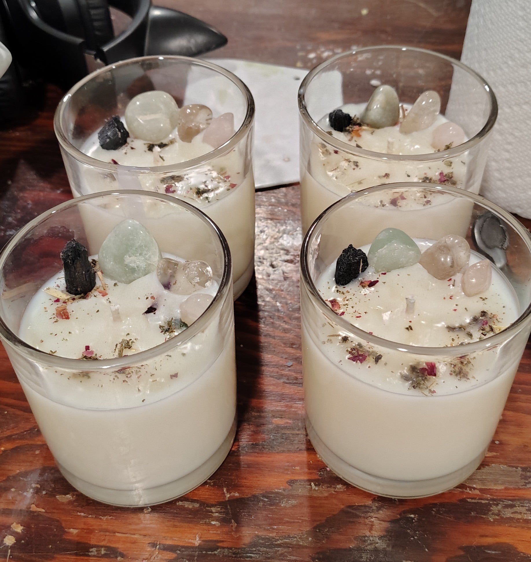 Four glasses of a creamy candle with decorative elements on a wooden surface